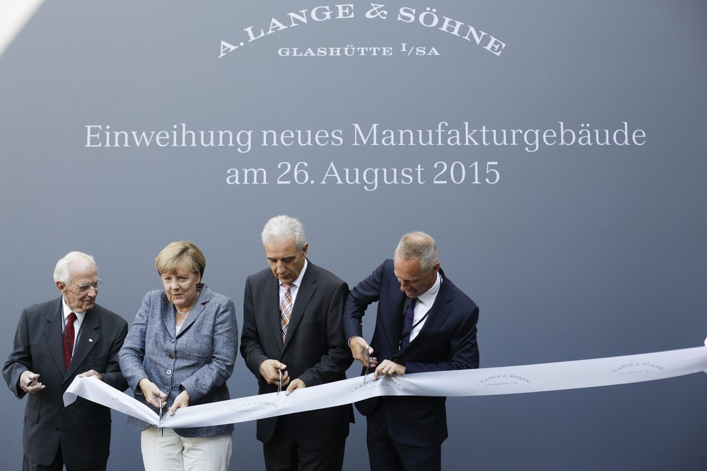 Walter Lange, refounder of Lange and Soehne watch makers, German Chancellor Angela Merkel, the State Premier of Saxony Stanislaw Tillich and the company's CEO Wilhelm Schmid cut the opening ribbon for the official opening of the new watch manufactory of Lange and Soehne watch makers in Glasshuette near Dresden, eastern Germany, on August 26, 2015. AFP PHOTO / POOL / MARKUS SCHREIBER
